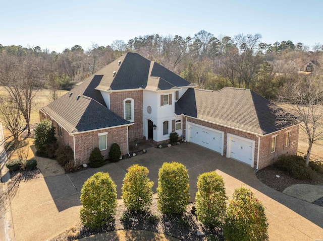 view of front of house with driveway, brick siding, and an attached garage