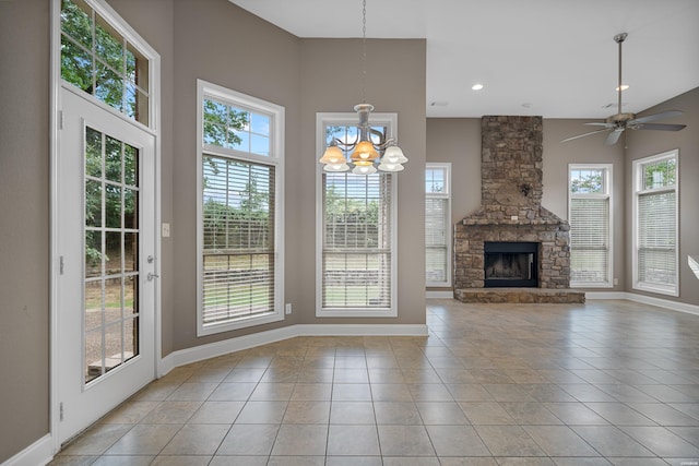 unfurnished living room with light tile patterned floors, baseboards, ceiling fan with notable chandelier, a fireplace, and recessed lighting
