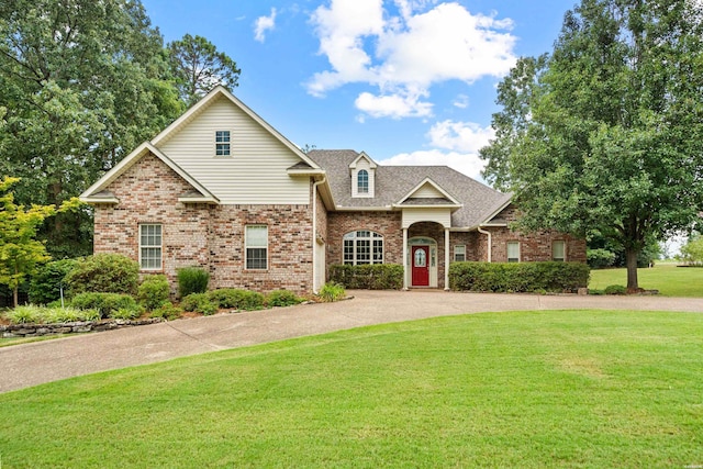 traditional home with brick siding, a shingled roof, and a front yard