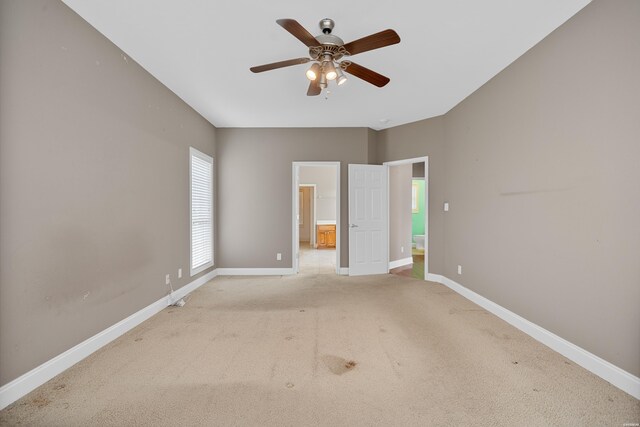 empty room featuring light carpet, ceiling fan, and baseboards