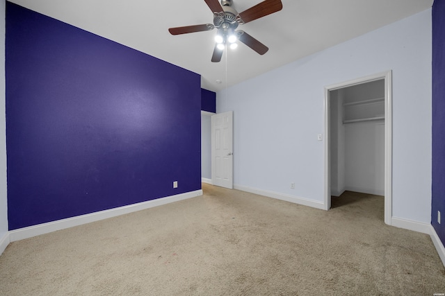 unfurnished bedroom featuring ceiling fan, baseboards, a closet, carpet, and a walk in closet