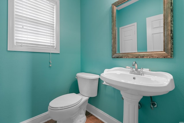 bathroom with toilet and baseboards