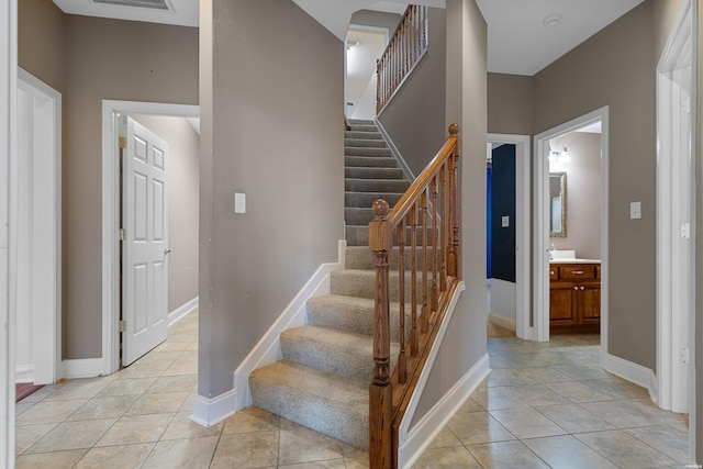stairway with tile patterned flooring, visible vents, and baseboards
