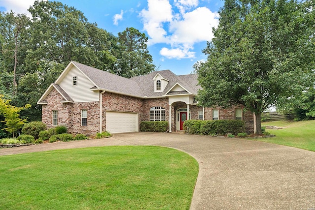 view of front of property with driveway, a shingled roof, a front yard, and brick siding