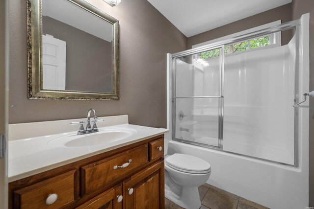 bathroom featuring toilet, shower / bath combination with glass door, tile patterned floors, and vanity