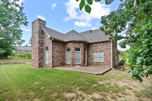 back of house with a patio, brick siding, a chimney, and cooling unit