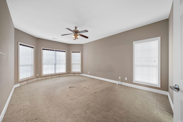 unfurnished room featuring carpet floors, a ceiling fan, and baseboards