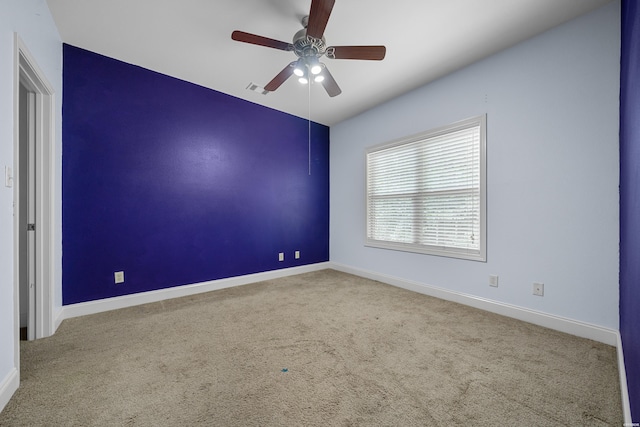 spare room with a ceiling fan, carpet flooring, visible vents, and baseboards