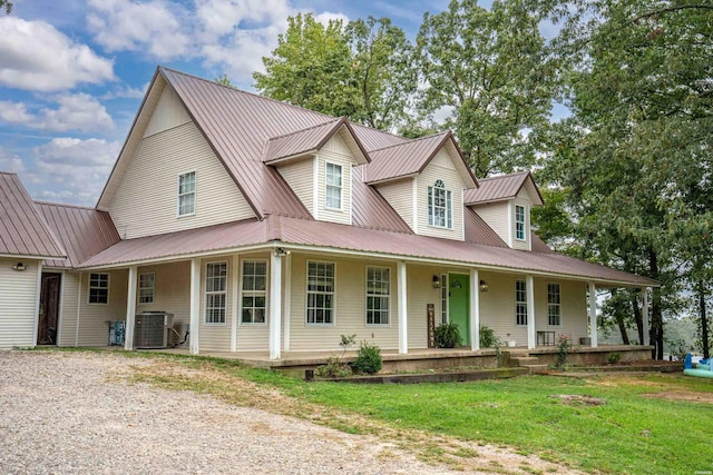 view of front of property with central air condition unit, metal roof, a front lawn, and a porch