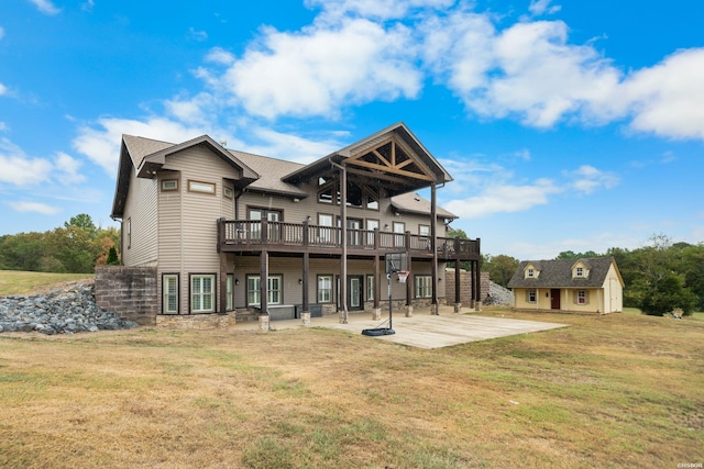 rear view of property featuring a patio area, an outbuilding, a deck, and a yard