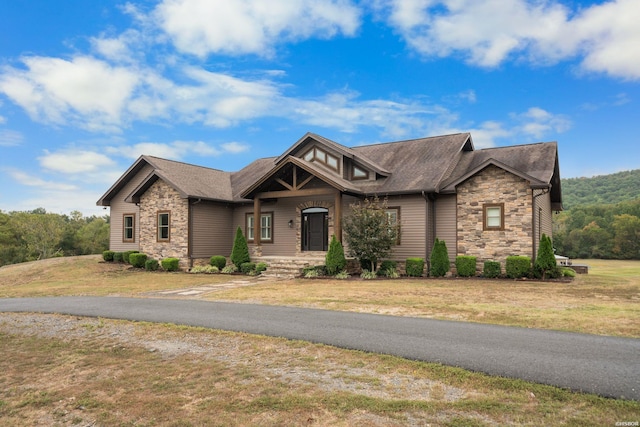 craftsman house with stone siding and a front lawn