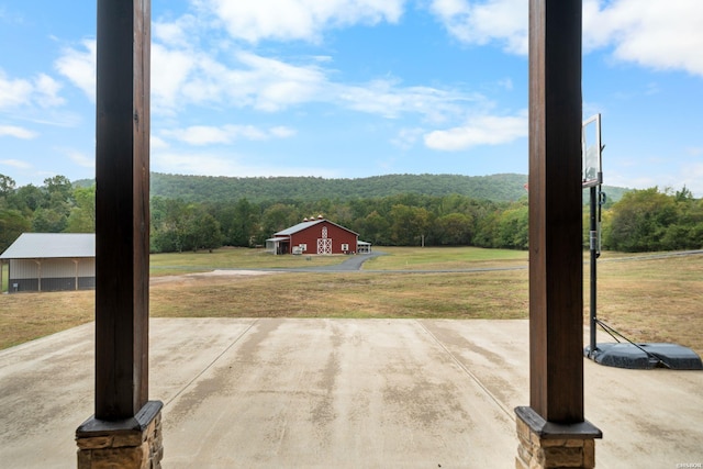 view of patio featuring a forest view and an outbuilding