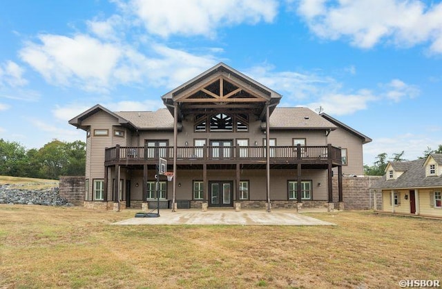 back of property featuring a patio area, a lawn, a wooden deck, and fence