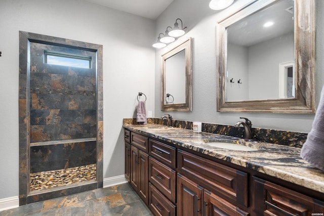 full bathroom with a walk in shower, stone finish flooring, a sink, and baseboards