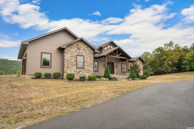 craftsman inspired home featuring stone siding and a front yard