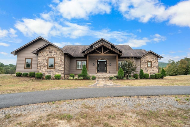 view of front of home with stone siding and a front yard