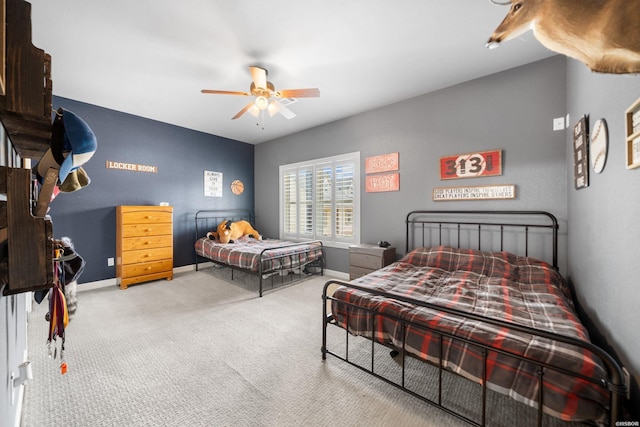 carpeted bedroom with ceiling fan and baseboards