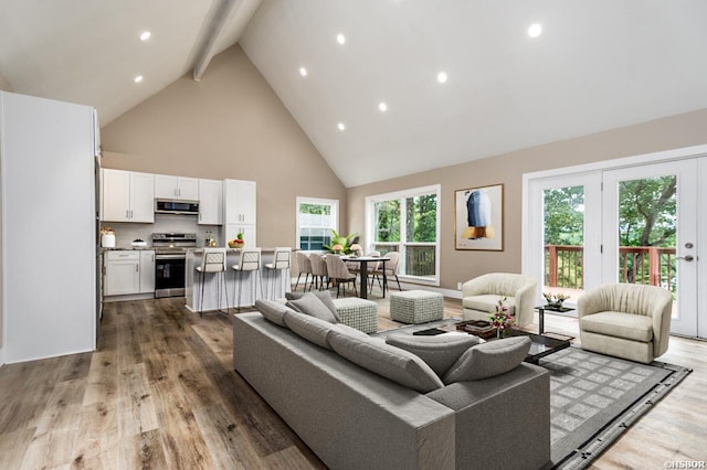 living room featuring high vaulted ceiling, recessed lighting, beam ceiling, and wood finished floors