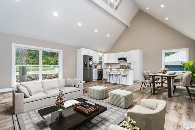 living room featuring light wood-style flooring, high vaulted ceiling, baseboards, and recessed lighting