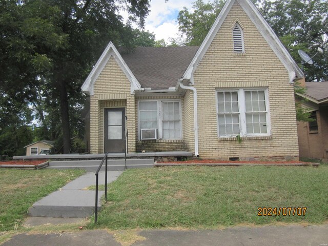 view of front facade featuring roof with shingles, brick siding, and a front lawn