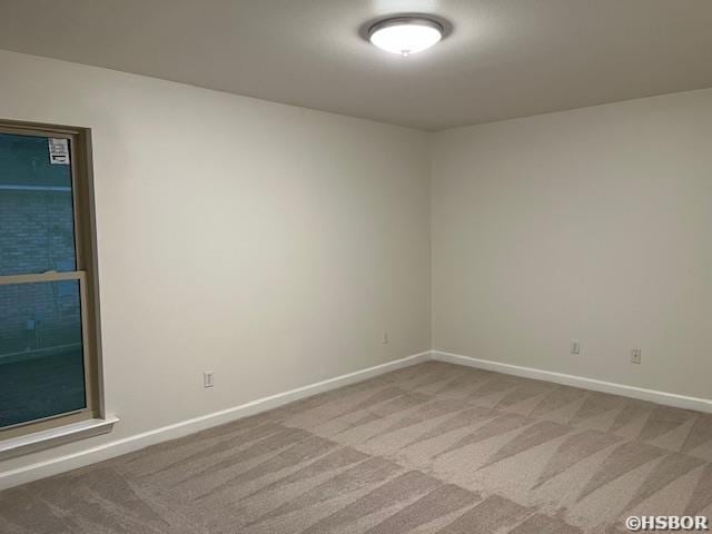 spare room with carpet and baseboards