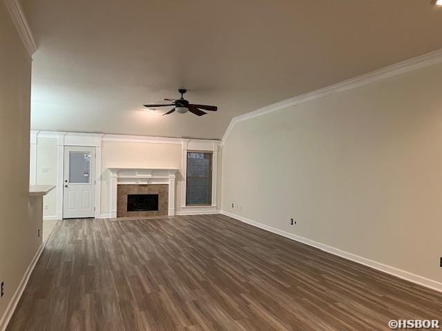 unfurnished living room featuring baseboards, a ceiling fan, a tiled fireplace, dark wood-style floors, and crown molding