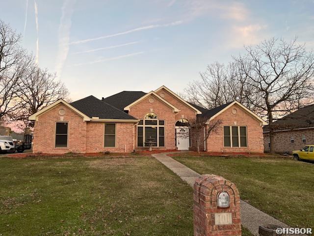 ranch-style house with brick siding and a front yard