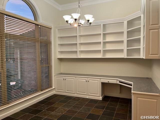 unfurnished office featuring an inviting chandelier, crown molding, and built in study area