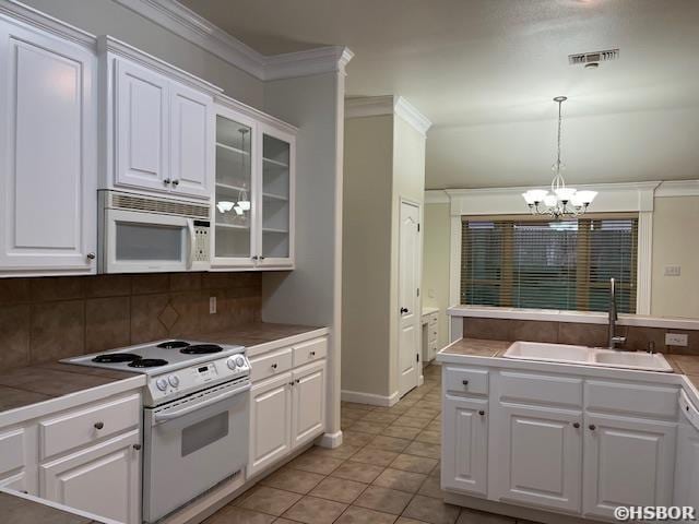 kitchen with crown molding, visible vents, white cabinets, a sink, and white appliances