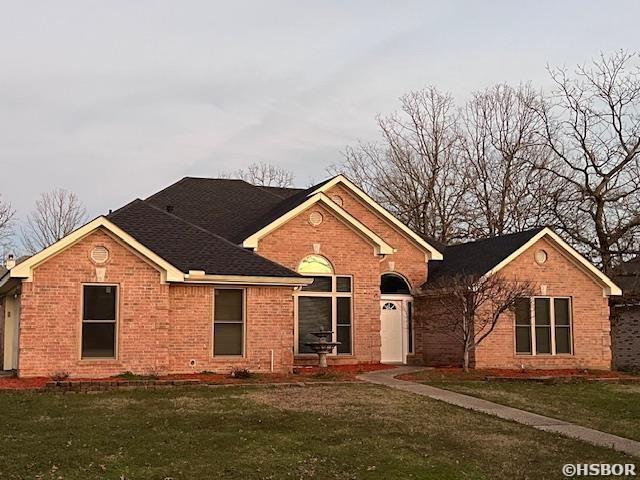 single story home with brick siding and a front lawn