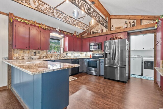 kitchen featuring vaulted ceiling with beams, a peninsula, appliances with stainless steel finishes, and separate washer and dryer