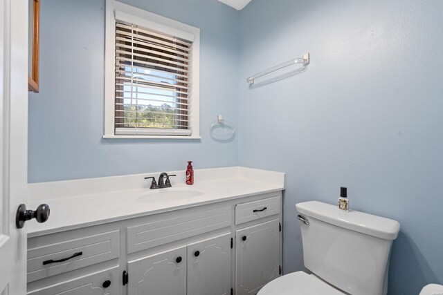 half bathroom featuring toilet and vanity