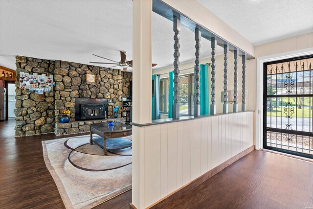 living room with ceiling fan, a textured ceiling, and dark wood-style flooring