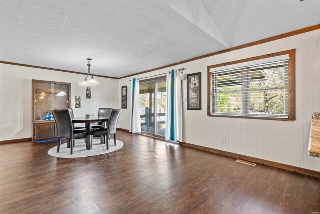 dining area featuring dark wood-style floors, ornamental molding, a textured ceiling, and visible vents