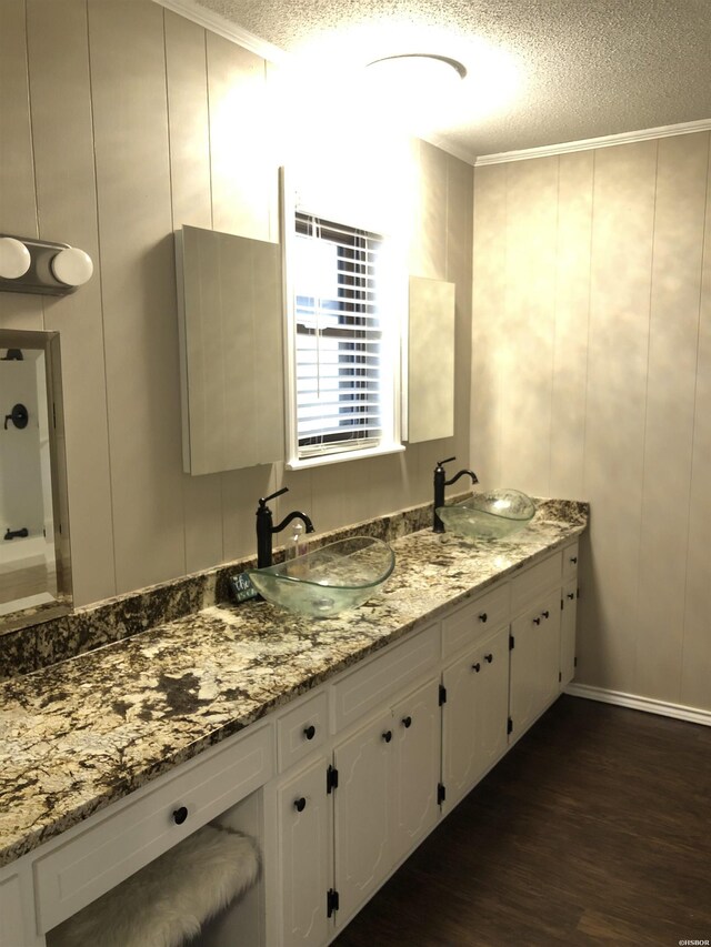 bathroom with a sink, a textured ceiling, and wood finished floors