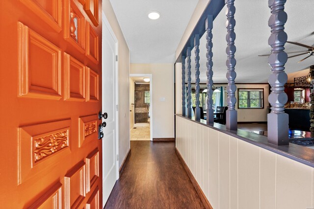 corridor featuring dark wood-style floors and baseboards