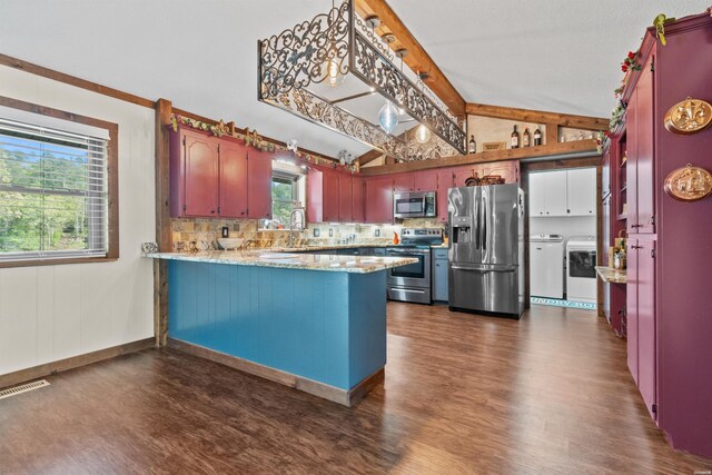 kitchen with vaulted ceiling with beams, a peninsula, washer and dryer, appliances with stainless steel finishes, and dark wood finished floors