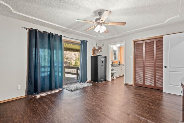 empty room with a textured ceiling, a ceiling fan, and dark wood-style flooring