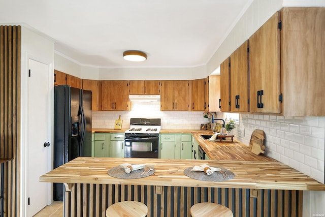 1405 Emory St, Hot Springs, AR 71913 - kitchen with gas range gas stove, under cabinet range hood, a sink, tasteful backsplash, and a peninsula