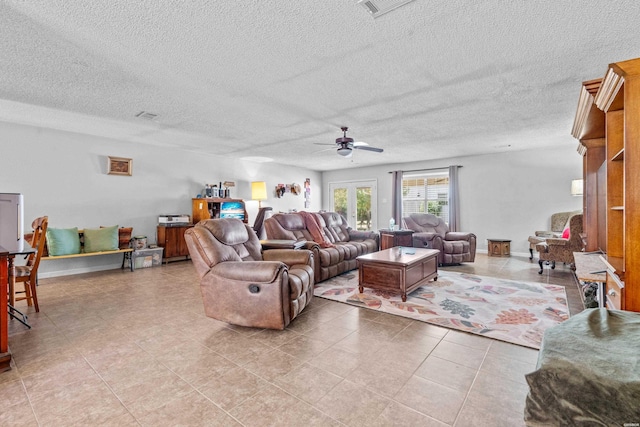 living room featuring visible vents, a ceiling fan, baseboards, and a textured ceiling