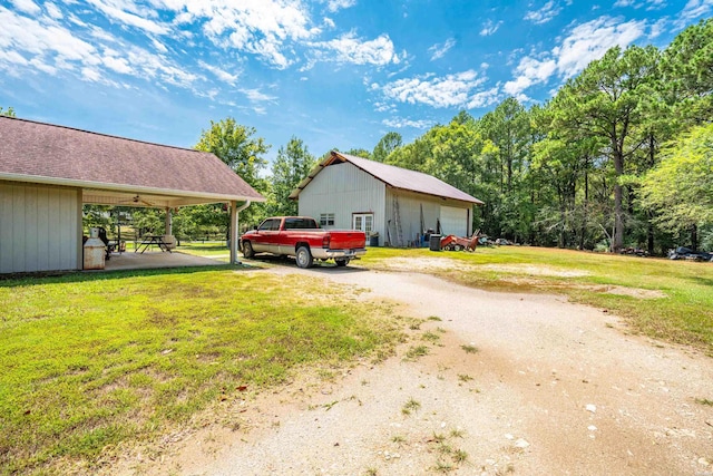 view of side of home featuring a garage, a lawn, and an outdoor structure