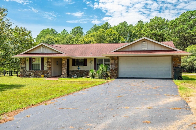 ranch-style home featuring a front lawn, an attached garage, stone siding, and driveway