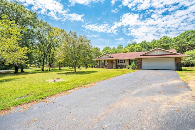 view of front facade featuring a garage, stone siding, a front yard, and aphalt driveway