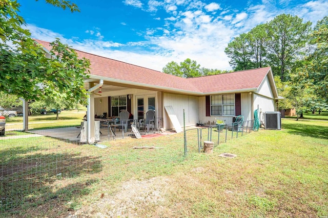 back of property with a patio, a lawn, central AC, and a shingled roof