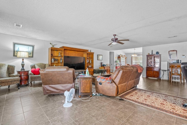 tiled living area featuring visible vents, a textured ceiling, and ceiling fan