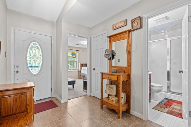 foyer with light tile patterned floors and baseboards