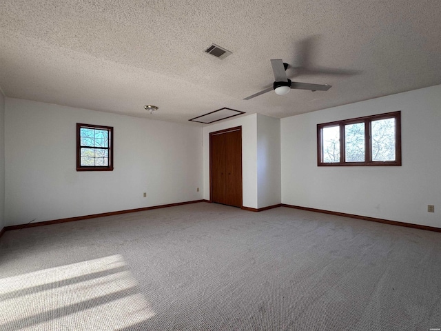 unfurnished room with light carpet, baseboards, visible vents, and a ceiling fan