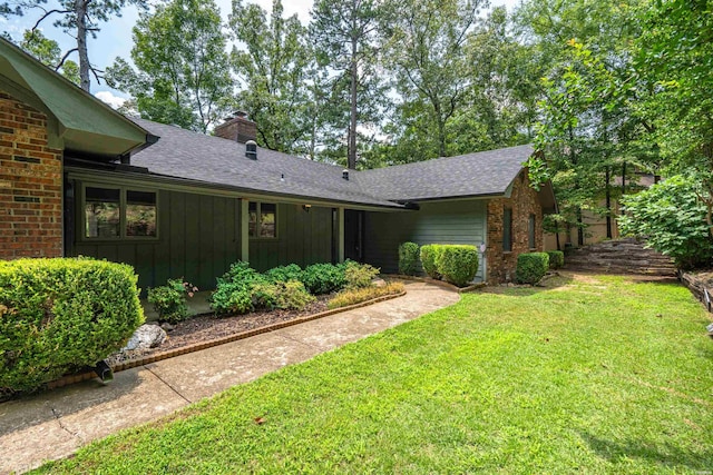 1200 Rock Creek Rd, Hot Springs, AR 71913 - rear view of house featuring board and batten siding, a yard, a chimney, a shingled roof, and brick siding