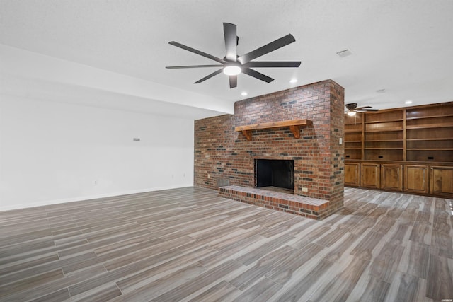 1200 Rock Creek Rd, Hot Springs, AR 71913 - unfurnished living room featuring ceiling fan, light wood-style flooring, a brick fireplace, recessed lighting, and baseboards