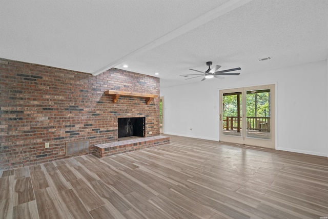1200 Rock Creek Rd, Hot Springs, AR 71913 - unfurnished living room with a ceiling fan, wood finished floors, a textured ceiling, baseboards, and a fireplace